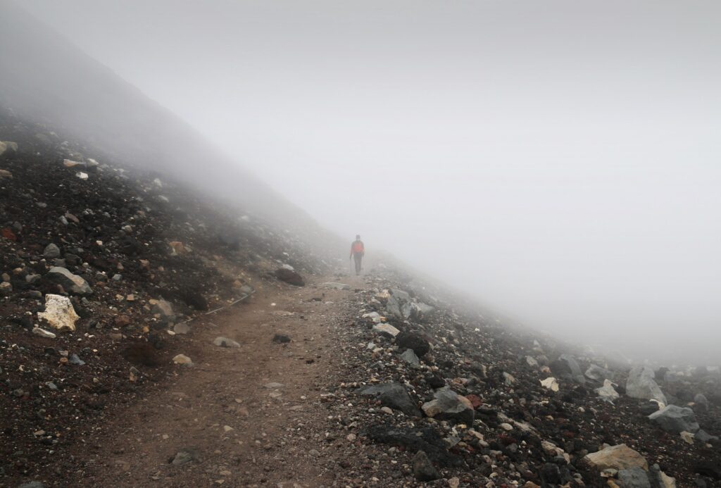 Climber walking alone on top of Mount Fuji on a misty morning.